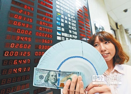 學者認為隨著美國聯準會如期升息，強勢美元格局持續，台灣央行可能在明年第1季升息。圖為行員手持美金現鈔。（本報資料照片） 