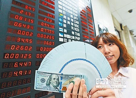 學者認為隨著美國聯準會如期升息，強勢美元格局持續，台灣央行可能在明年第1季升息。圖為行員手持美金現鈔。（本報資料照片） 