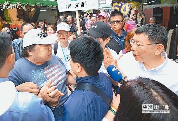 柯文哲13日到東門市場拜票，也有長者對取消敬老金表達不滿，現場安全人員立刻將其隔開。（王英豪攝）
