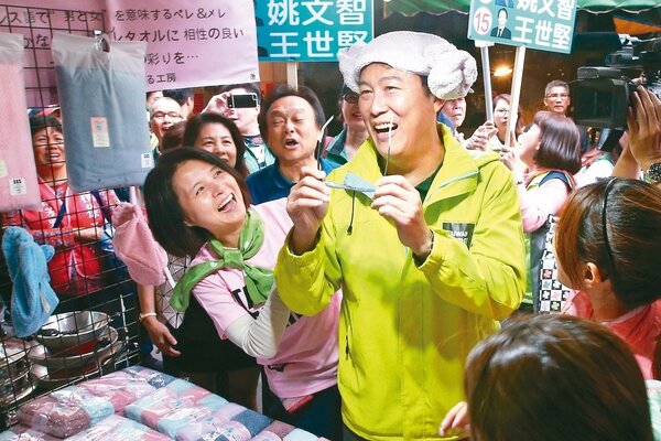 民進黨台北市長候選人姚文智（右）昨與妻子潘瓊琪（左）到市場掃街，姚隨性戴上毛巾摺成的浴帽。 記者蘇健忠／攝影