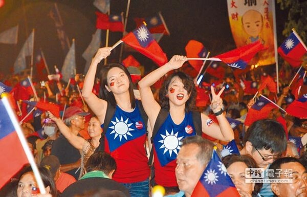 韓國瑜岡山大會戰晚會上，兩名正妹與民眾14日揮舞國旗，高呼韓國瑜凍蒜。（林瑞益攝）