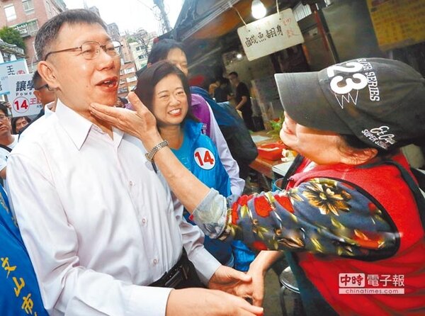 台北市長候選人柯文哲（左）14日前往景美市場拜票，1名熱情的攤商握手之餘，還興奮地伸手摸摸柯文哲臉頰。（范揚光攝）