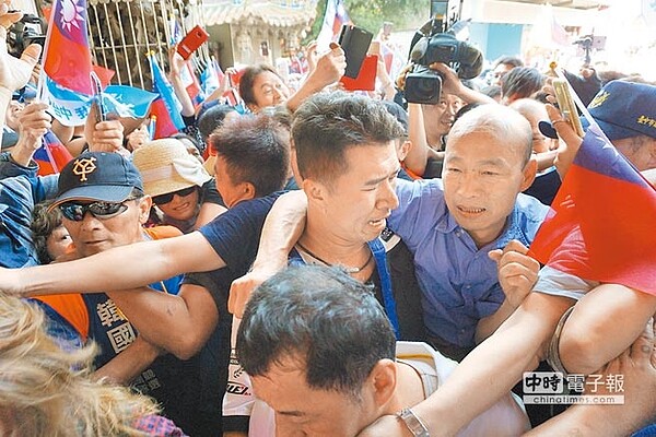 韓國瑜寸步難行,最後被隨扈駕著往大殿移動。(王文吉攝)
