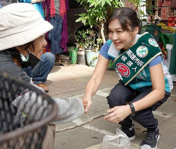 民進黨高市長候選人陳其邁的另一半吳虹(右)到市場拜票,看見年長的攤販,總是蹲下身問安握手。記者楊濡嘉/攝影