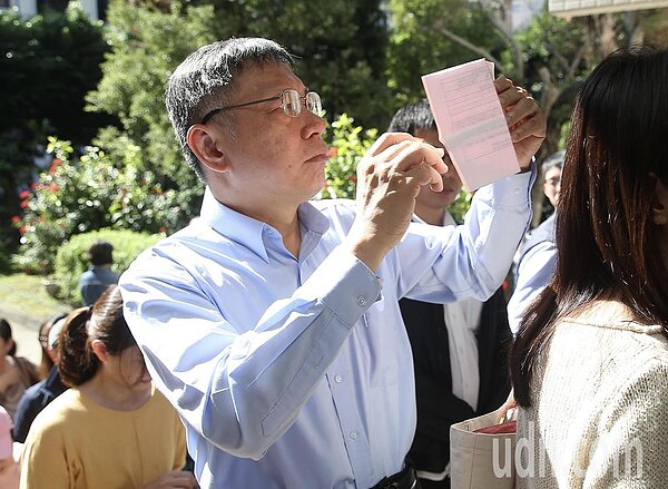九合一選舉與十案公投上午登場,台北市長候選人柯文哲到北市圖啟明分館投票,跟著民眾排隊投票,並在投票前仔細查看投票通知單。記者余承翰/攝影