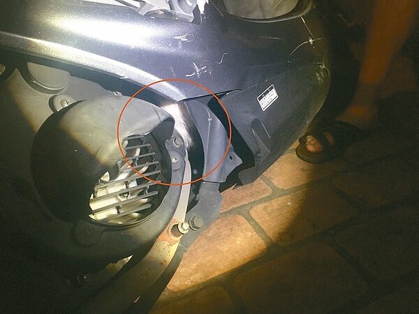 小貓(紅色圓圈處)卡在機車引擎內,警民合作救出貓咪。 記者林佩均/翻攝