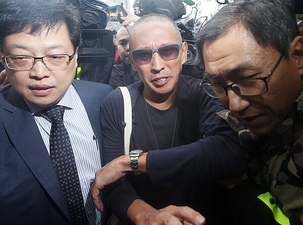 導演鈕承澤(中)被控性侵,在神隱22小時後,今天上午前往大安分局說明案情。理了一個大光頭的鈕承澤,一下車隨即被大批媒體推擠搶拍,最後只能藉由警方開道「護送」被「推」進大安分局,過程中,鈕承澤不時露出驚訝與苦笑的表情。記者杜建重/攝影