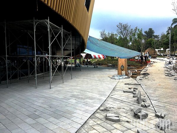 花博后里園區花艷館的地磚尚在舖設中,現場堆放未完工的器材仍一片零亂。(圖/記者黑中亮攝影)