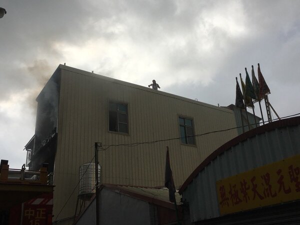 台南市公園路上午民宅火警一名婦人爬上加蓋鐵皮屋頂呼救。圖／台南市消防局提供