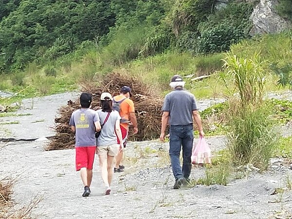 游姓教練妻子(灰衣)在兒子(左一)陪同下,前往神秘海灘進行招魂儀式。 記者江婉儀/攝影