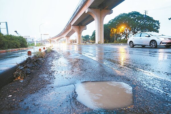 高雄市因豪雨多處道路出現坑洞,已造成約兩百名騎士摔傷。圖為高雄楠梓學專路前。 記者劉學聖/攝影