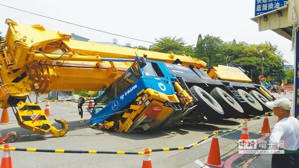 台南市南區利南街道路塌陷，造成一輛吊車陷入馬路。（程炳璋翻攝）