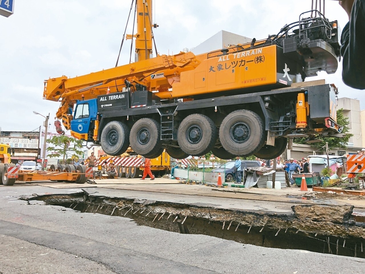 台南市昨天調動兩部大型重機械進場作業，將深陷天坑的百噸吊車吊起。 記者邵心杰／攝影