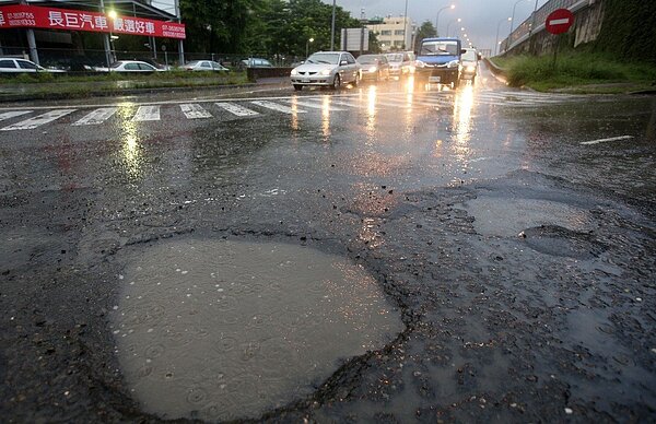 立法院預算中心調查,至2016年止,全國地方政府累計債務餘額已逾1兆,地方政府應立即補救財政黑洞。圖為高雄市豪大雨過後,高雄楠梓旗楠公路坑洞景象。圖/聯合報系資料照