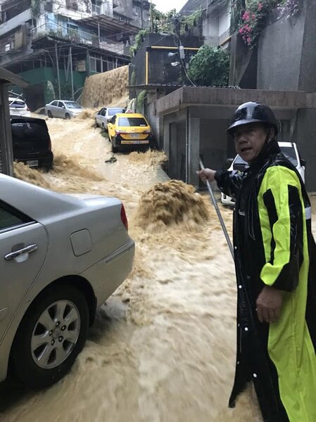 安樂區新西街207巷淹水嚴重，馬路人孔蓋噴出滾滾泥水。圖／居民陳怡欣提供