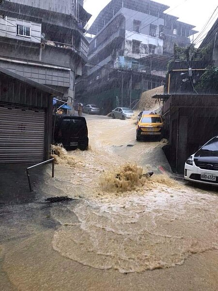 安樂區新西街207巷淹水嚴重,馬路人孔蓋噴出滾滾泥水。圖/居民陳怡欣提供