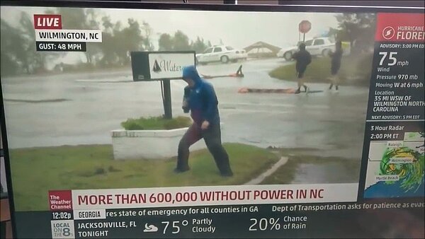 美國「天氣頻道」記者賽德爾日前播報佛羅倫斯颶風時,在鏡頭前數度站不穩,此時背景卻有兩名路人從容經過,讓網友質疑記者是否誇大風雨威力。翻攝 YouTube/whatever.