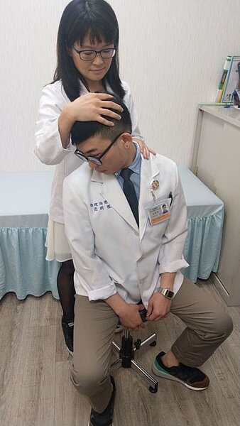 醫師簡可欣(後)、物理治療師范創傑(前)示範頸部簡易伸展操,坐著配合呼吸,往右,往左,往上、往下,往右下45度、往左下45度,配合呼吸,各3秒。 記者趙容萱/攝影