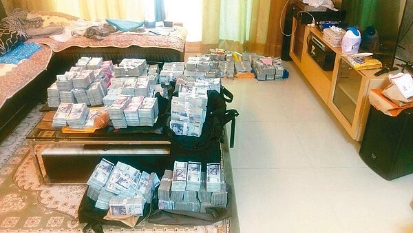 調查局偵破「雅格瑞科技集團」吸金案,調查官在主嫌洪明秋住家保險箱搜出七千餘萬元現金。 圖/報系資料照