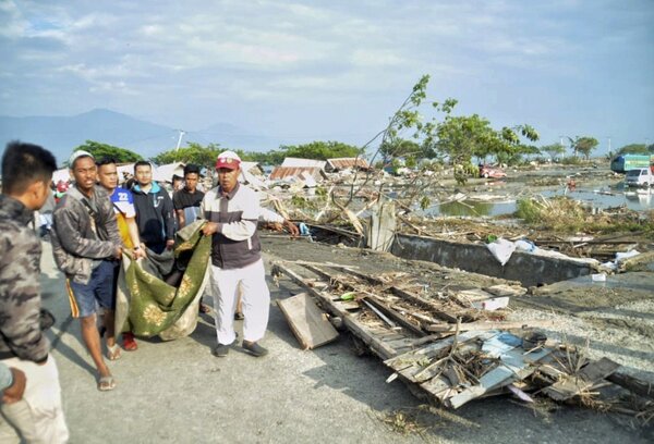 印尼官員說，昨天規模7.5強震引發海嘯侵襲蘇拉威西島，導致近400人喪命，海灘上數以百計準備節慶活動的人下落不明。災區巴路市和鄰近地區至今已發生約100次餘震。（圖／美聯社）
