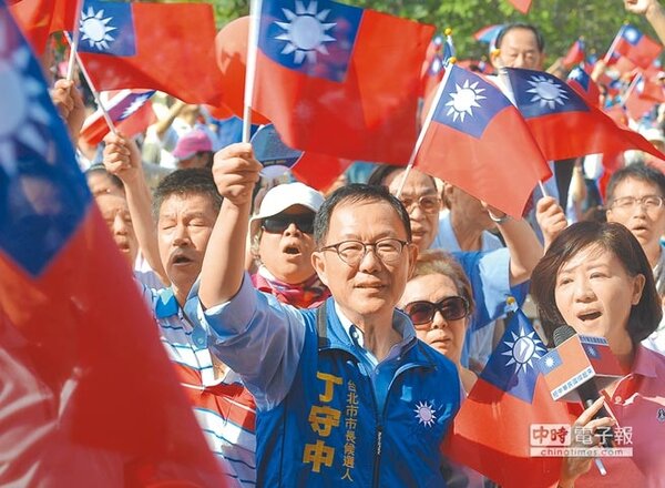 國民黨台北市長參選人丁守中（中）6日出席「把中華民國撐起來愛國旗活動」，與支持者一起揮舞國旗唱國歌。右為國民黨立委王育敏。（季志翔攝）