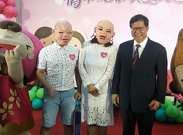 桃園市國慶市民聯合婚禮,新人曾永桔(左)、夏若嵐(右)戴上「聖誕面具」與市長鄭文燦拍照。記者曾增勳/攝影