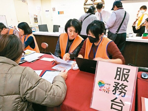 昨天一早有不少民眾到台北車站服務台完成春節返鄉專車取票作業,台東縣長饒慶鈴(中)也上陣當志工為取票的旅北台東縣民服務。 記者羅紹平/翻攝