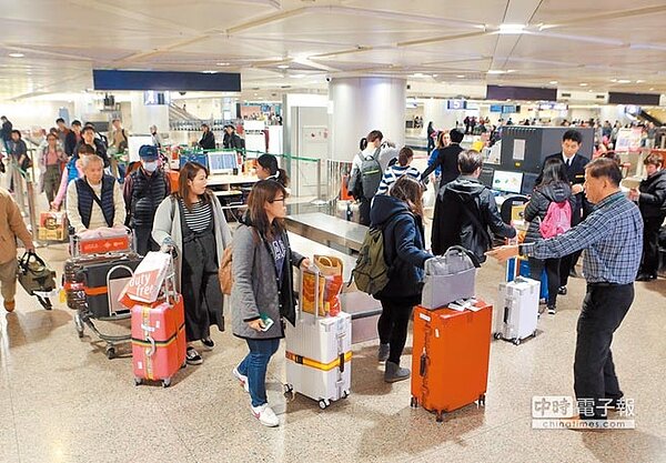 關務署台北關15日試辦提升高風險地區入境旅客手提行李抽檢比例,為防疫把關,雖然立馬查獲夾帶豬肉丸子,但造成入境旅客在綠線檯前大排長龍。(陳麒全攝)