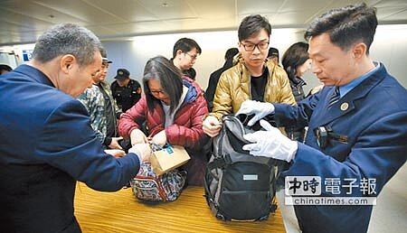 桃園機場為加強防疫人力,警政署18日起調派110名保一警力支援桃機,圖為剛下飛機的入境旅客正在排隊受檢。(范揚光攝)