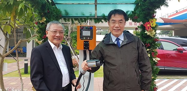 中油在台南建置全台第一座智慧綠能加油站,台南市長黃偉哲(右)今天在中油董事長戴謙陪同下參觀,手持機車充電槍。 記者修瑞瑩/攝影