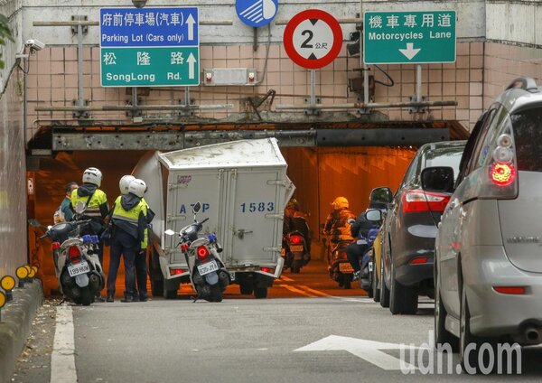 台北市一輛小貨車趕著送貨，沒有注意到車行地下道的限高，車子就卡在基隆路與松壽路交叉往北的地下道口，警方獲報趕到現場。記者鄭超文／攝影 