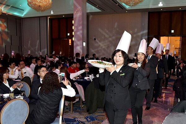 永慶加盟三品牌桃區聯合尾牙的上菜秀,由店東長擔任,為的是感謝員工一年來的努力和付出。(圖/永慶房屋提供)