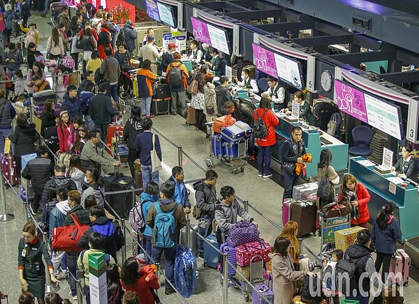 明天是春節9天連假的第一天,不少民眾今天提早放假出國,上午桃機第二航廈報到櫃台前擠滿排隊的民眾。記者鄭超文/攝影