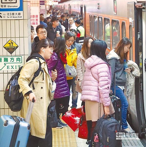 農曆春節連續假期的第一天,熙來攘往的車站出現返鄉過年人潮,在候車的月台旅客帶著行李,魚貫的進入火車。(季志翔攝)
