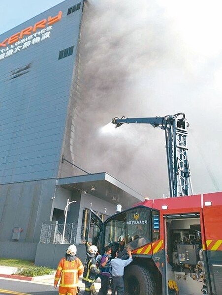 嘉里大榮觀音物流中心昨火警,消防隊到場灑水灌救,並使用安全梯進入二樓,陸續救出二名阮姓移工。 記者曾健祐/翻攝