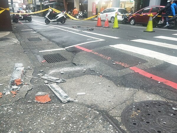 基隆市仁二路、延平街口一棟大樓外牆屋簷突出的部分發生磚磚剝落,整個水泥夾雜十多磚塊往下砸,停在路邊一輛白色轎被砸到,車燈破裂、車頂凹一個洞。記者游明煌/攝影
