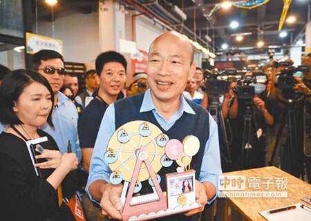 
高雄市長韓國瑜捧著手作的愛情摩天輪，手作上有他與女兒韓冰的照片，他笑得開心。（林瑞益攝）
 