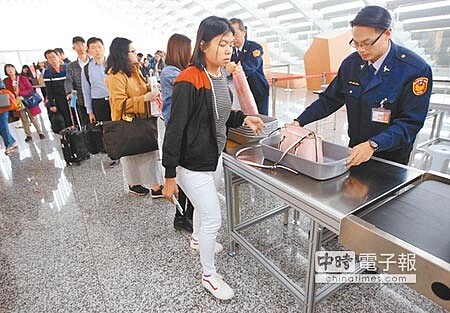 
越南已被列為非洲豬瘟疫區，在桃園機場一航廈，搭乘越南航班的旅客排隊檢查手提行李。（范揚光攝）
 