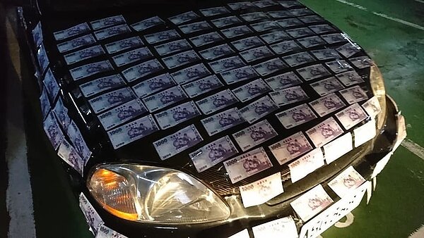 基隆市陳先生，今天清晨，到社區停車場開車要上班，嚇然發現停在附近的一輛車，被貼滿千元鈔，嚇一大跳。圖／民眾提供