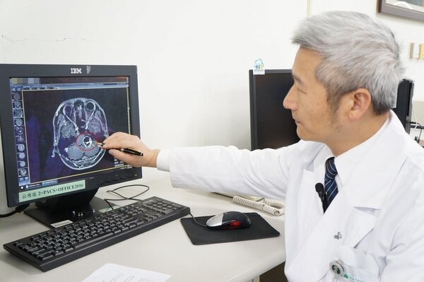 陳金城醫師手指處（紅圈）為病人腦內三公分大的聽神經瘤。圖／大林慈濟醫院提供