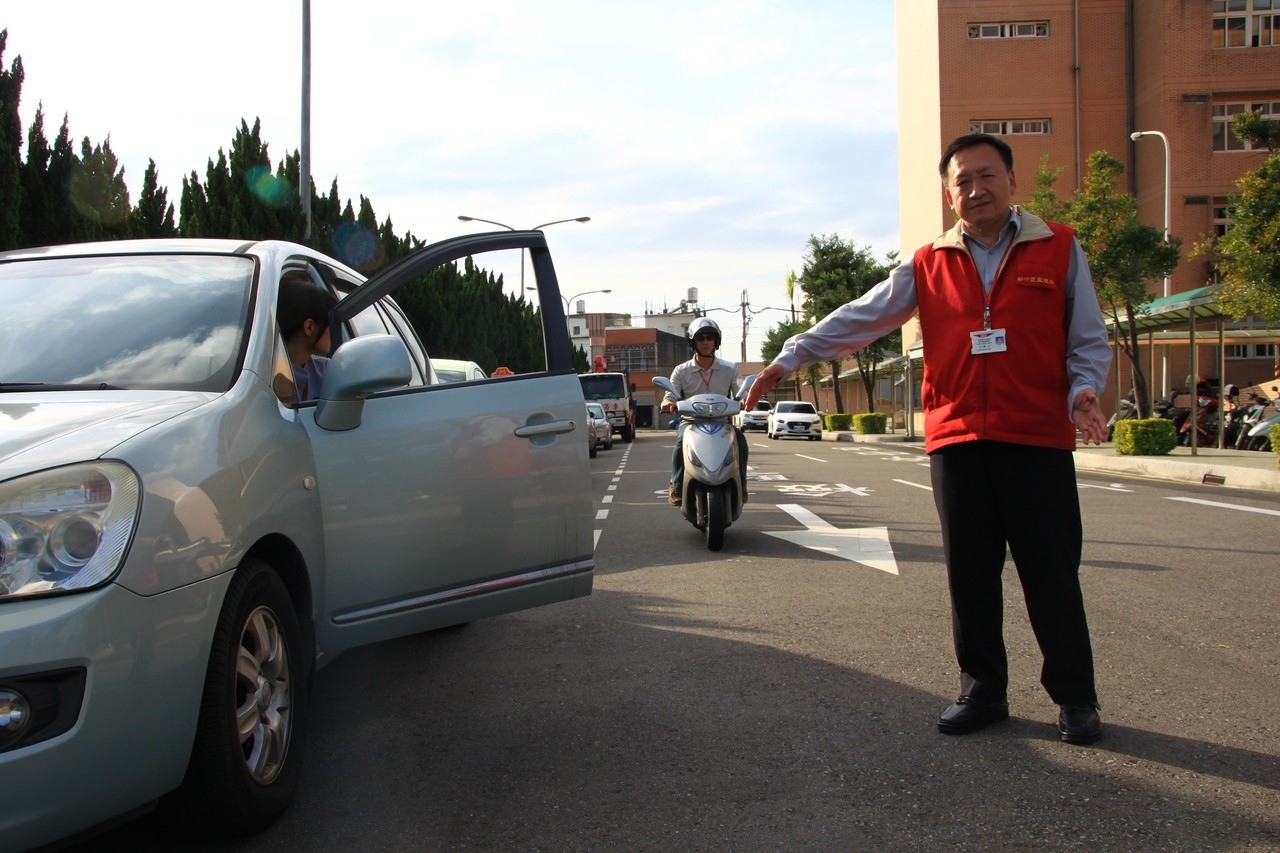 新竹區監理所副所長江澍人（右）以手臂距離，談到騎士經過路旁臨停車輛時，要減速並保持兩大步以上的距離，以避免車門突然打開發生事故。記者郭政芬／攝影