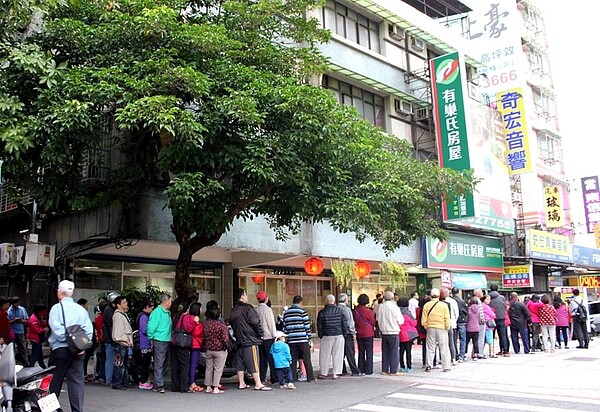 有巢氏房屋新莊中正丹鳳店發起捐當期發票,送高麗菜,民眾大排長龍,領高麗菜做公益。(圖/有巢氏房屋提供)