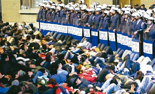 2014年太陽花學運，占領行政院的反服貿民眾，躺在地上與警方對峙。 圖／聯合報系資料照片