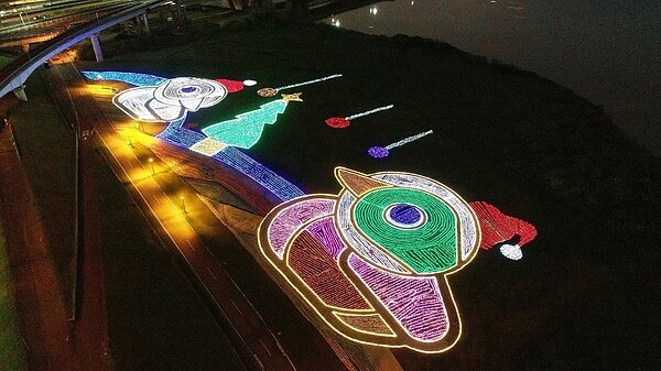 新北市鴨鴨公園以寶特瓶、光碟片、廢輪胎及布料等環保素材結合當季草花灌木,組成浪漫溫馨的「環保聖誕鴨鴨」,夜間搖身一變成為大型繽紛的光雕地景。記者陳珮琦/翻攝