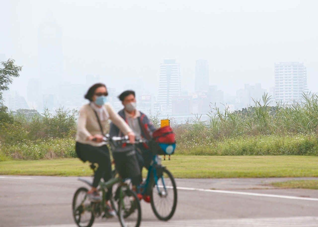 昨天上午西半部灰濛濛，有的是霧或低雲、有的是空氣品質不佳，騎單車民眾擔心空汙，紛戴上口罩。 記者王騰毅／攝影