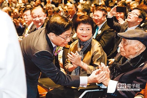 台大8日舉行校長接任典禮,管中閔(左)從教育部次長林騰蛟手中接下聘書,正式成為台大新任校長,現場歡呼聲不斷,管走向父親緊握雙手致意。(郭吉銓攝)