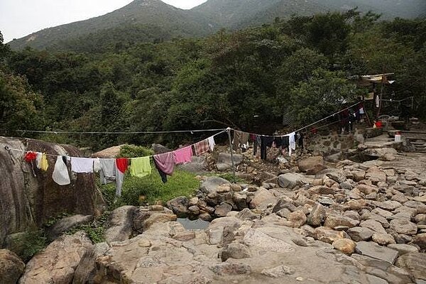 晾曬的衣物和自然風光形成強烈對比。(蔡正邦攝)