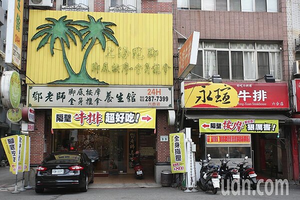 高雄市六合夜市外有業者掛出創意布條吸客,左方的腳底按摩店,外頭高掛著「隔壁牛排超好吃→」,而右邊的牛排店,布條則寫道「←隔壁按摩很厲害」,創意行銷的手法,讓行經此路的民眾很難不注意。記者劉學聖/攝影