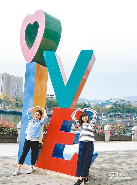 高雄市觀光局推廣愛情產業鏈，圖為民眾到愛河打卡景點拍照。（林瑞益翻攝）