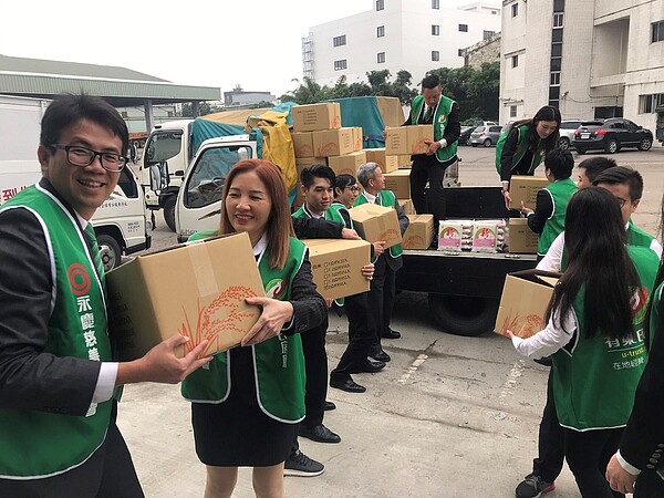 擔任志工的有巢氏房屋同仁，接力運送愛心白米物資上車。（圖／有巢氏房屋提供）